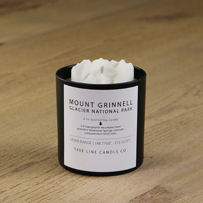  A white soy wax replica candle of Mount Grinnell Glacier National Park  in a round, black glass.