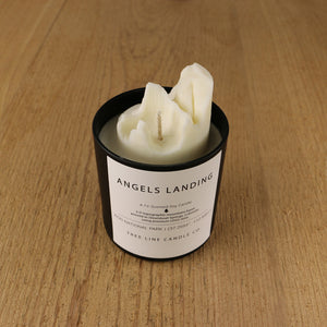  A white soy wax replica candle of Angels Landing in a round, black glass.