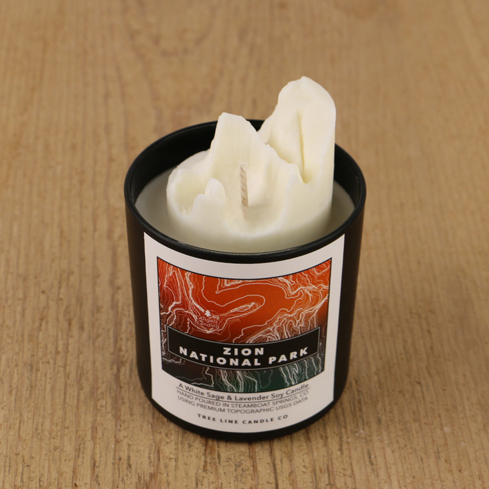  A white soy wax replica candle of Angels Landing in a round, black glass.