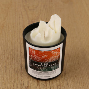  A white soy wax replica candle of Angels Landing in a round, black glass.