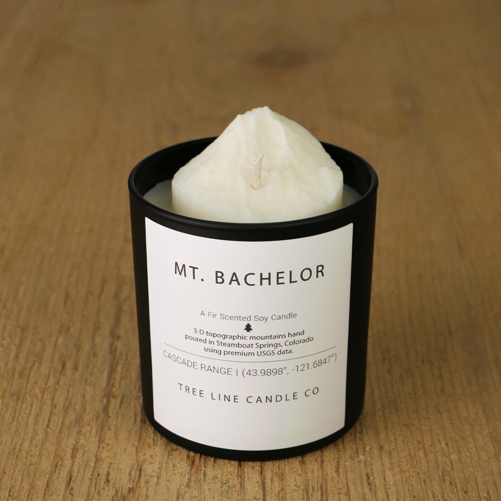  A white soy wax replica candle of Mount Bachelor in a round, black glass.