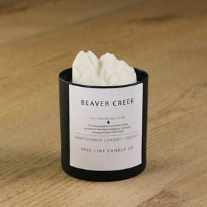  A white soy wax replica candle of Beaver Creek mountain in a round, black glass.