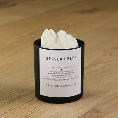  A white soy wax replica candle of Beaver Creek mountain in a round, black glass.