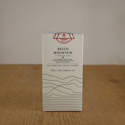 A white box with black lettering and a red and white Tree Line Candle Co.  logo.