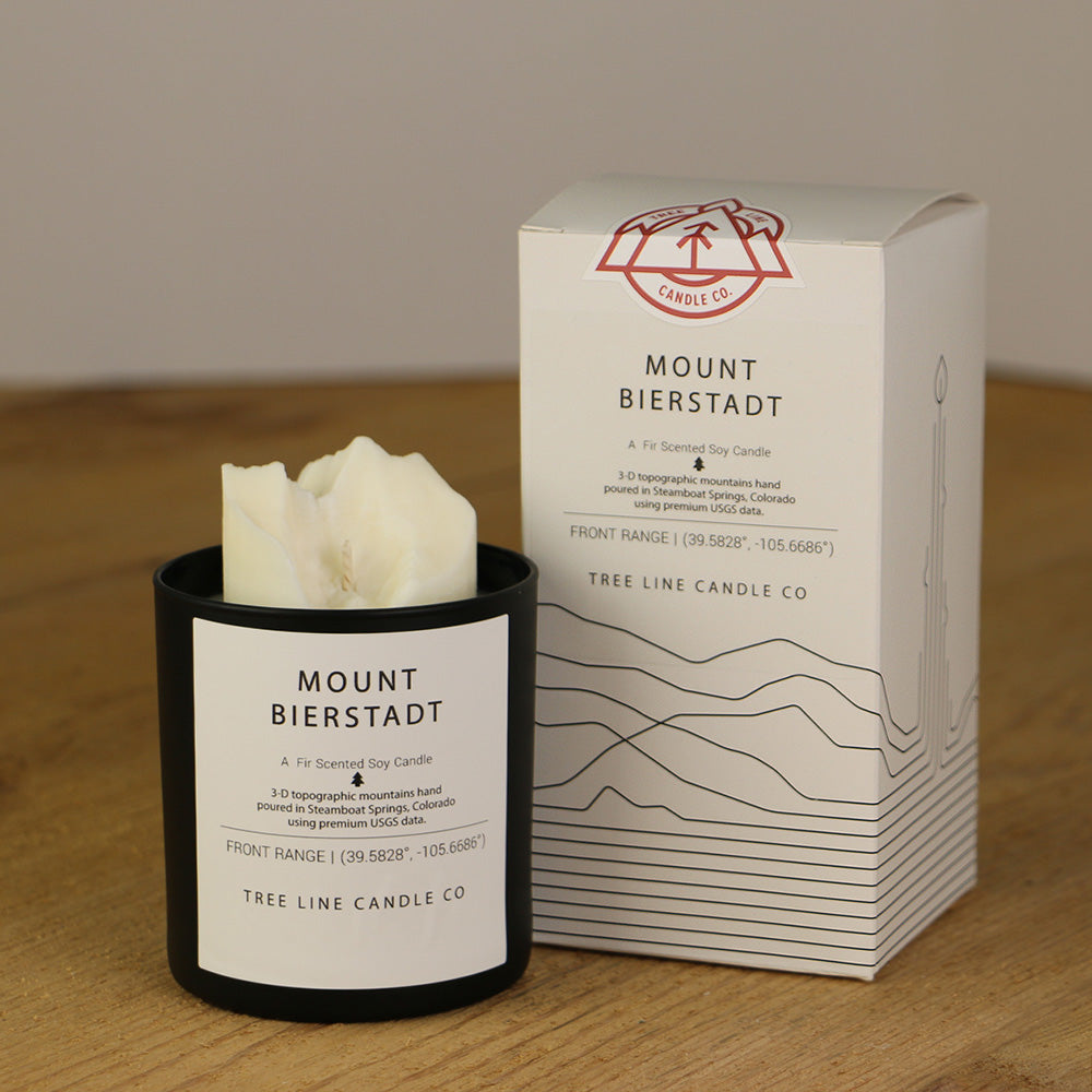 A white wax replica candle of Mount Bierstadt next to a white box with red and black lettering.