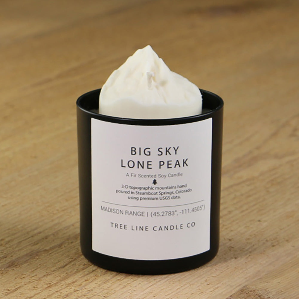  A white soy wax replica candle of Big Sky Lone Peak in a round, black glass.