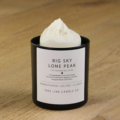  A white soy wax replica candle of Big Sky Lone Peak in a round, black glass.