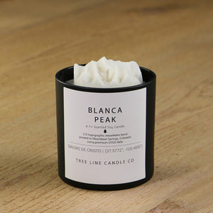  A white soy wax replica candle of Blanca Peak in a round, black glass.