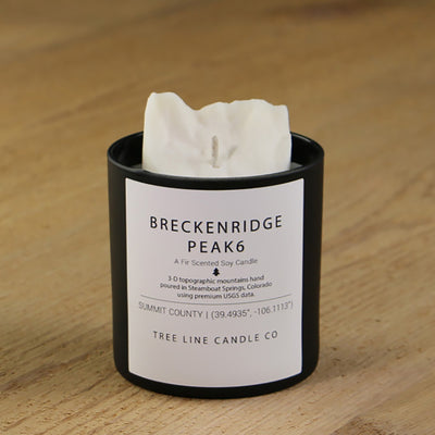  A white soy wax replica candle of Breckenridge Peak 6 in a round, black glass.