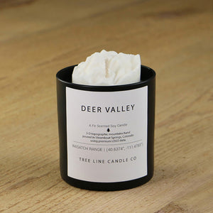  A white soy wax replica candle of Deer Valley mountain in a round, black glass.