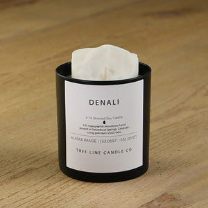  A white soy wax replica candle of Denali summit in a round, black glass.