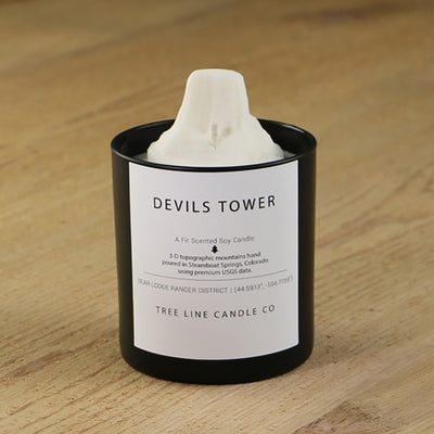 A white soy wax replica candle of Devil Tower in a round, black glass.