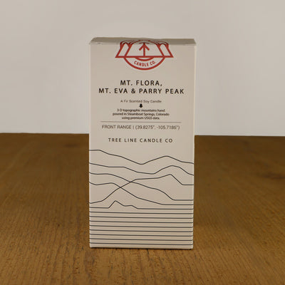 A white box with black lettering and a red and white Tree Line Candle Co.  logo.