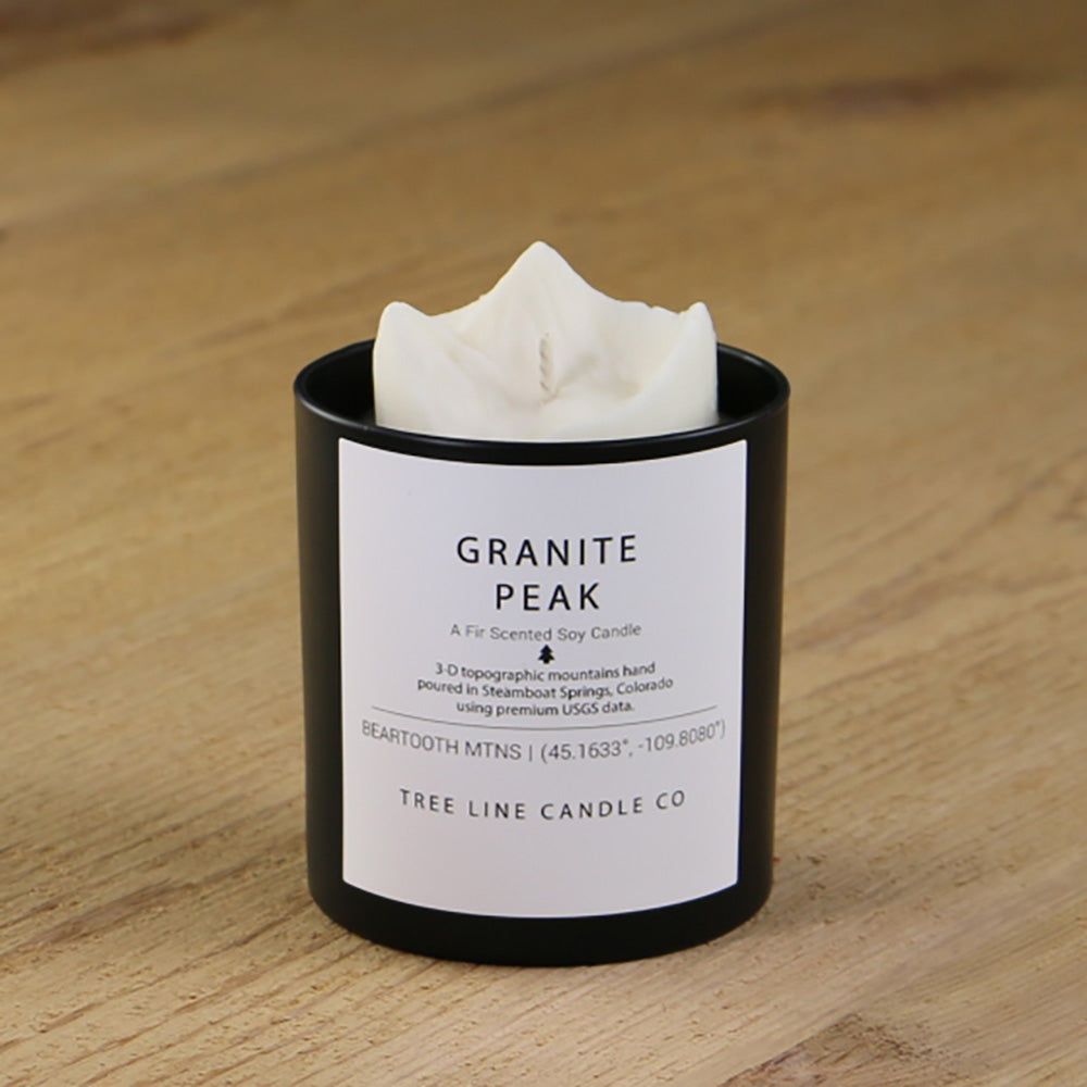  A white soy wax replica candle of Granite Peak in a round, black glass.