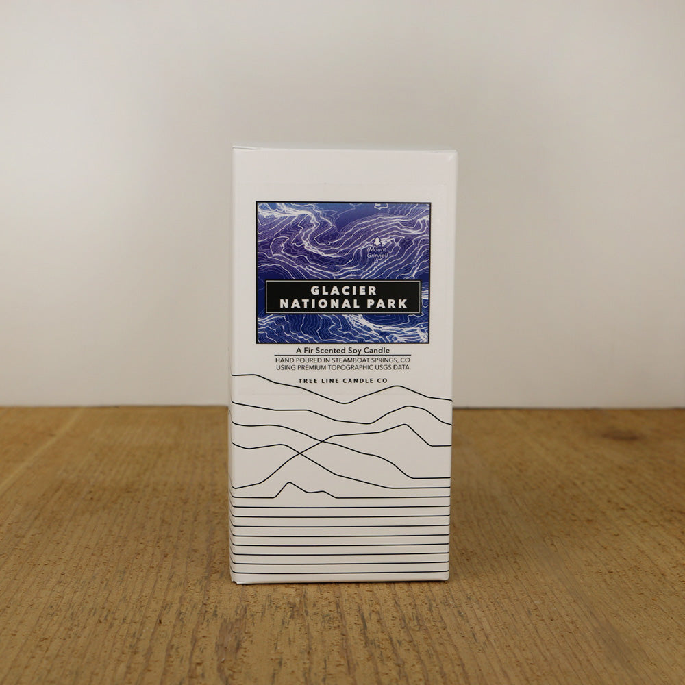 A white box with a purple and black label with topography lines by Tree Line Candle Co.