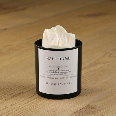  A white soy wax replica candle of Half Dome in a round, black glass.