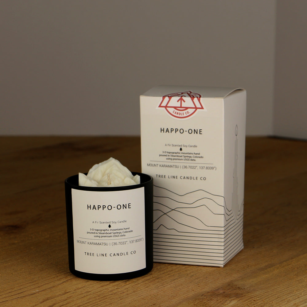 A white wax replica candle of Happo-One next to a white box with red and black lettering.