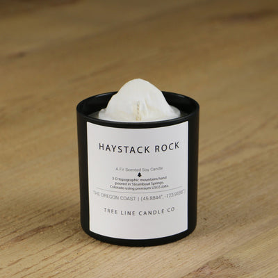  A white soy wax replica candle of Haystack Rock in a round, black glass.