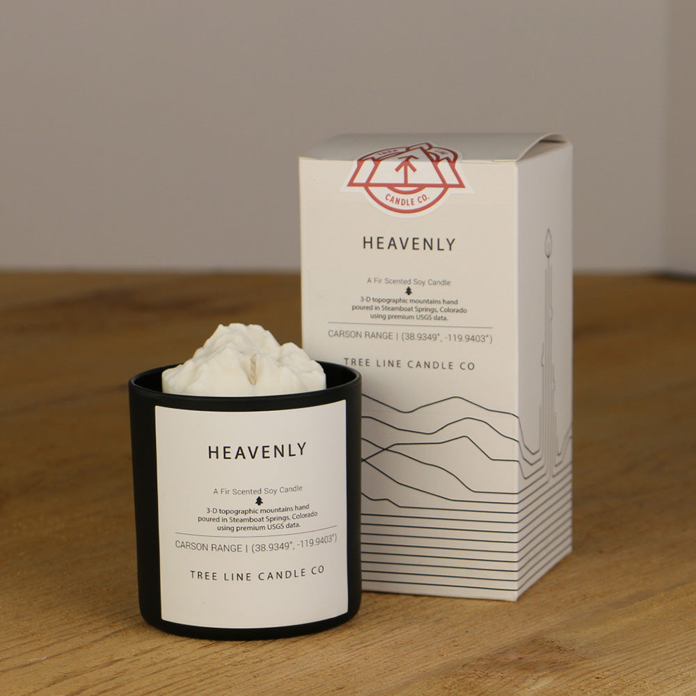 A white wax replica candle of Heavenly summit next to a white box with red and black lettering.
