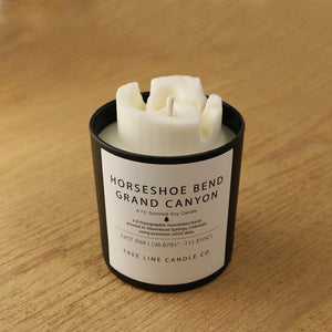  A white soy wax replica candle of Horseshoe Bend Grand Canyon in a round, black glass.