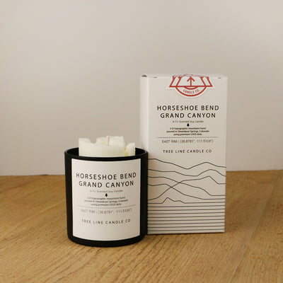 A white wax candle named Horseshoe Bend is next to a white box with red and black lettering.