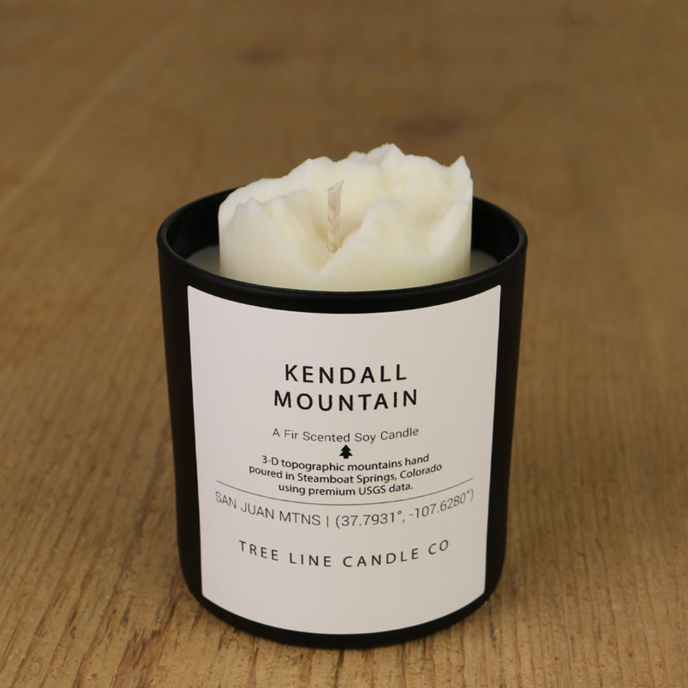 A white soy wax replica candle of Kendall Mountain in a round, black glass.