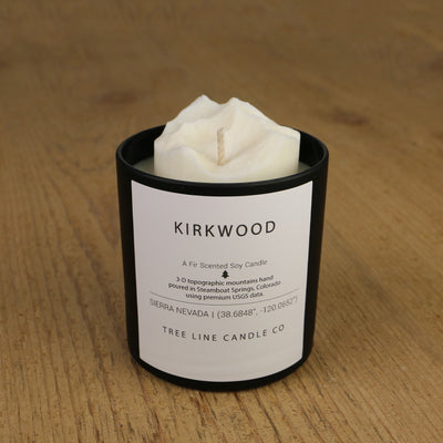  A white soy wax replica candle of Kirkwood in a round, black glass.