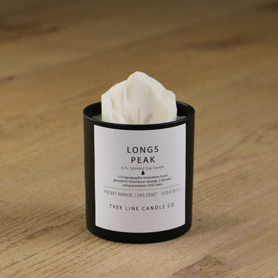  A white soy wax replica candle of Longs Peak in a round, black glass.