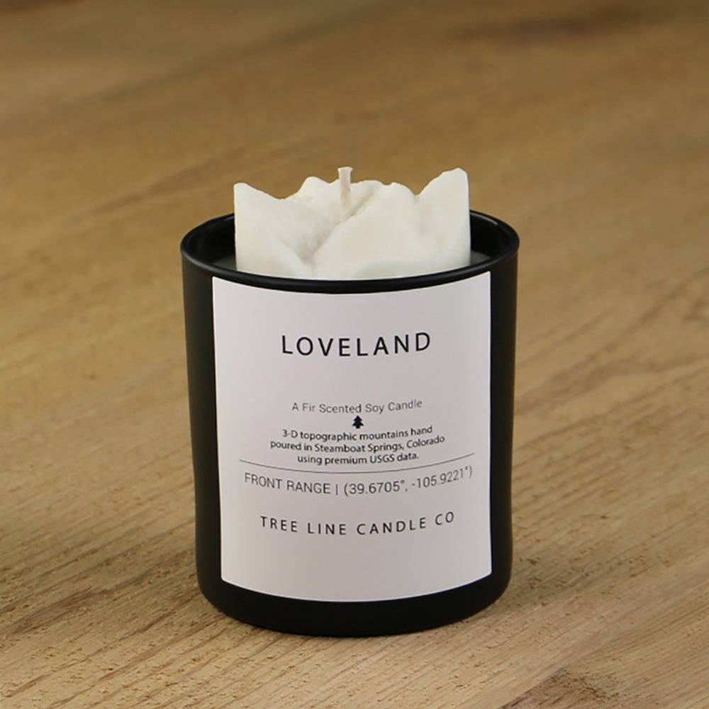  A white soy wax replica candle of Loveland ski area  in a round, black glass.