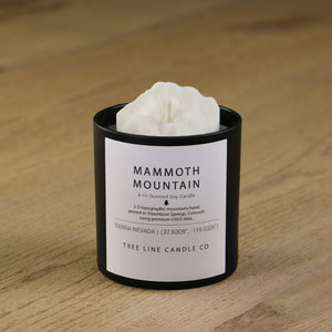 A white soy wax replica candle of Mammoth Mountain in a round, black glass.