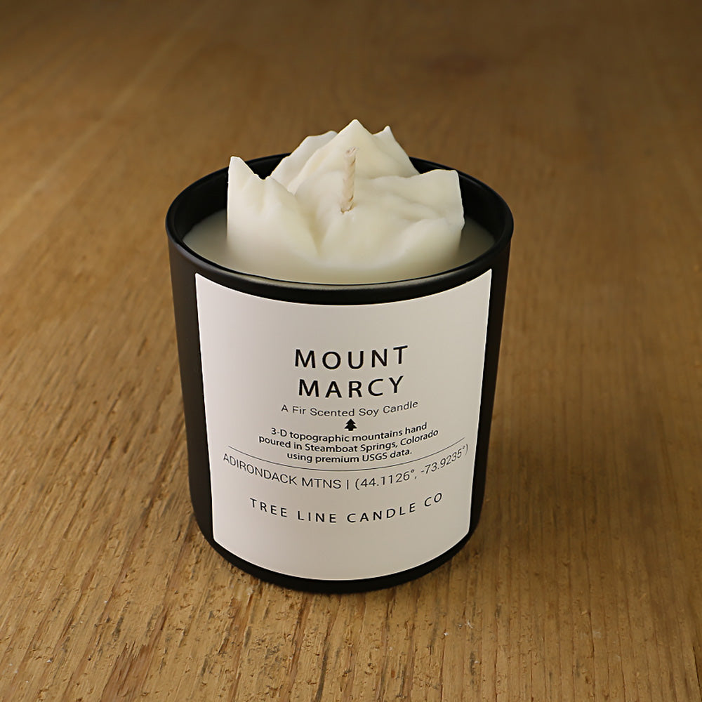  A white soy wax replica candle of Mount Marcy in a round, black glass.