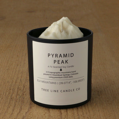  A white soy wax replica candle of Pyramid Peak in a round, black glass.