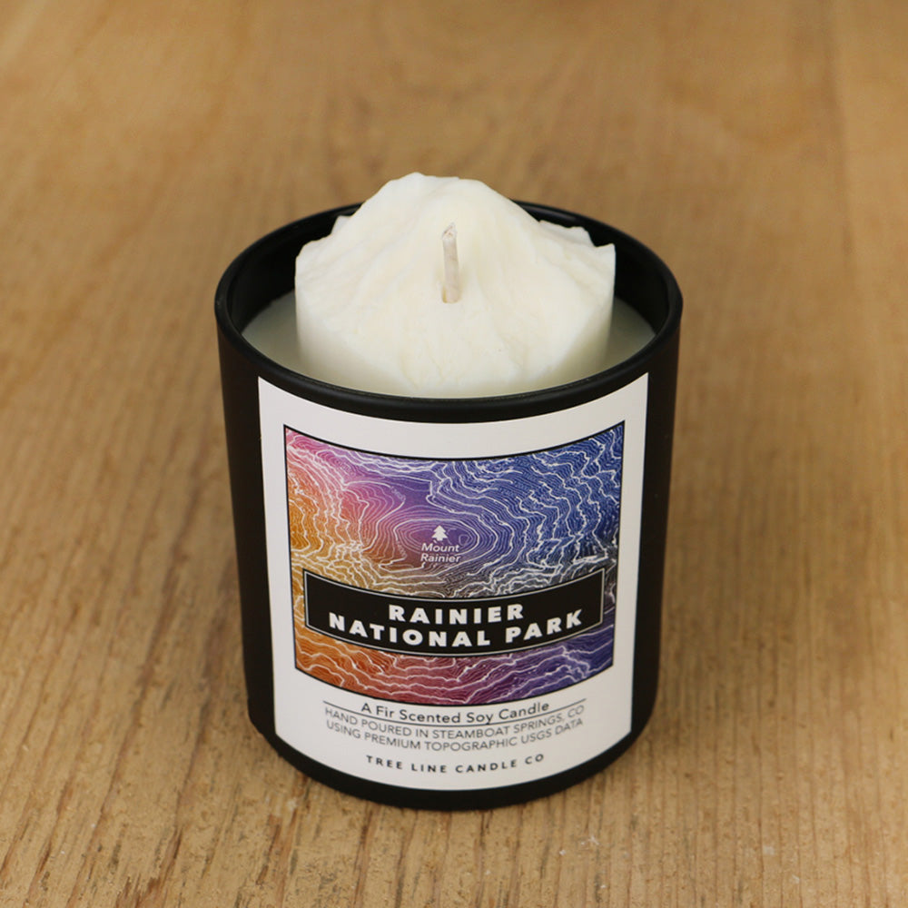  A white soy wax replica candle of Mount Rainier in a round, black glass.