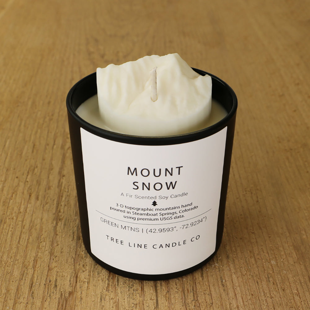  A white soy wax replica candle of Mount Snow in a round, black glass.