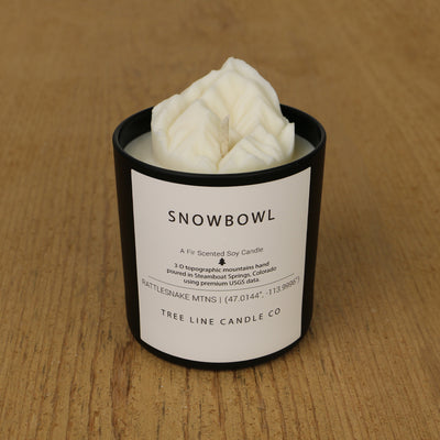  A white soy wax replica candle of Snowbowl in a round, black glass.