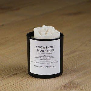 A white soy wax replica candle of Snowshoe Mountain in a round, black glass.