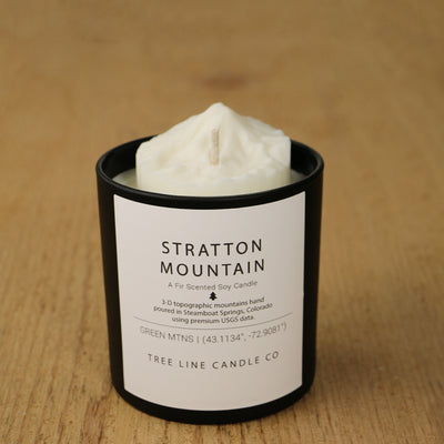  A white soy wax replica candle of Stratton Mountain in a round, black glass.