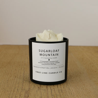  A white soy wax replica candle of Sugarloaf Mountain in a round, black glass.
