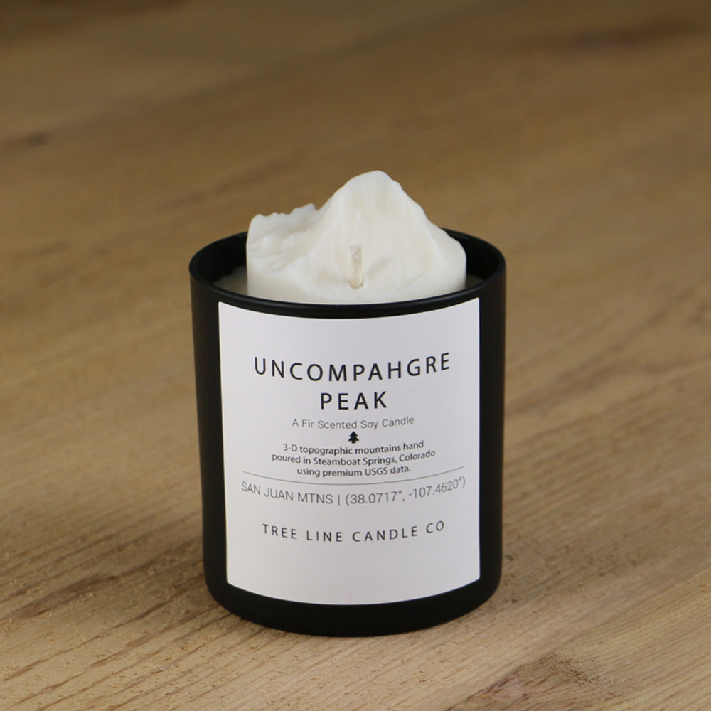  A white soy wax replica candle of Uncompahgre Peak in a round, black glass.