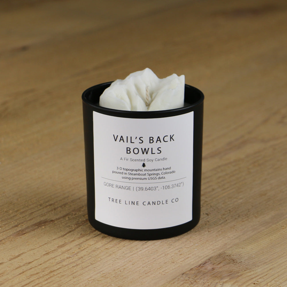  A white soy wax replica candle of Vail's Back Bowls in a round, black glass.
