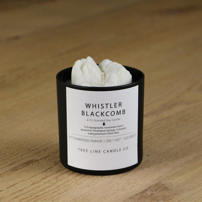  A white soy wax replica candle of Whistler Blackcomb summits in a round, black glass.